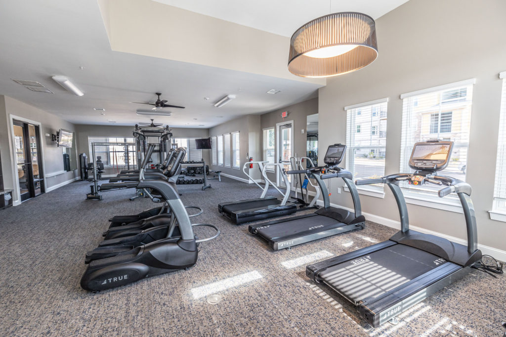 Fitness center with cardio equipment, lots of windows, ceiling fans, and strength equipment