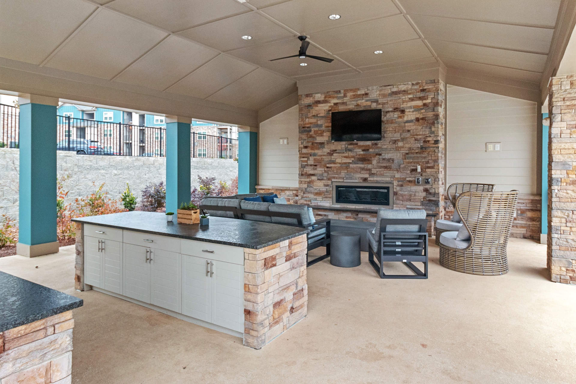 Outdoor lounge area with brick fireplace, two outdoor sofas, and 3 outdoor armchairs